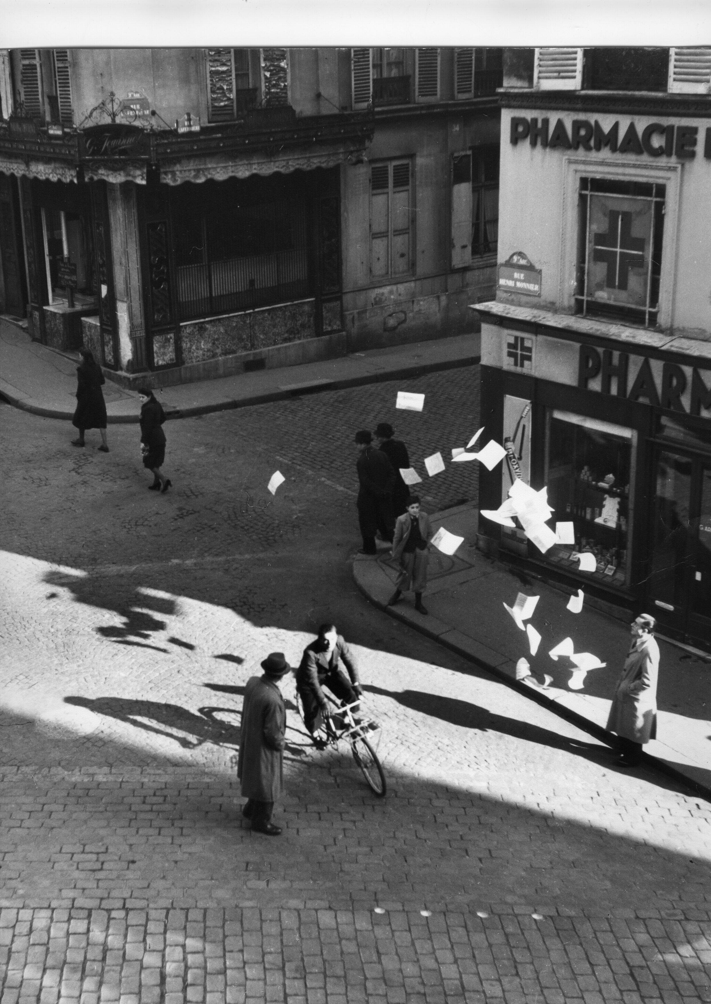 Un combatiente de la resistencia distribuye folletos en la rue Henry Monnier de París como parte de una serie de fotografías reconstruidas por Robert Doisneau en imprentas clandestinas durante la Segunda Guerra Mundial |  Colección AAMRN, Museo Nacional de la Resistencia en Champigny-sur-Marne.